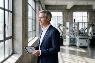 Homme d'affaires en costume dans une usine moderne