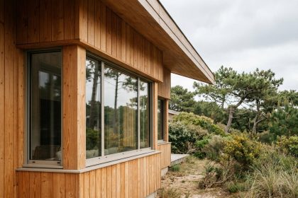 Maison en bois moderne en Charente-Maritime entourée de pins maritimes avec bardage en douglas et grandes baies vitrées